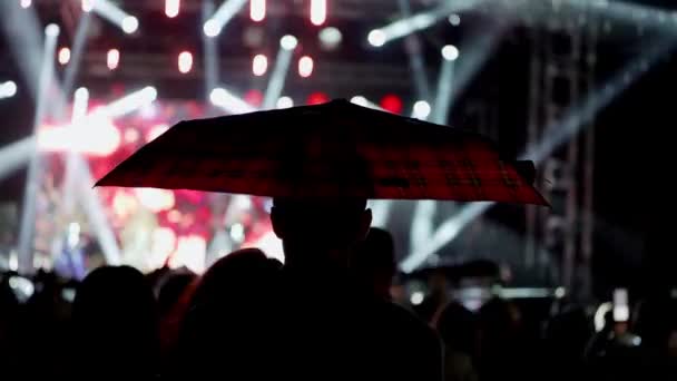 Glada Människor Tittar Fantastisk Musikkonsert Paraplyer Regnet Glada Fans Hoppar — Stockvideo