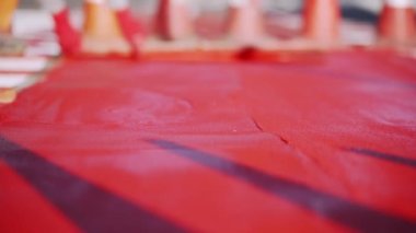 Yeni bisiklet yolu. Yaya geçitleri ve bisiklet yolları olan yollar inşa ediliyor. Bisiklet şeridi işaretleri. İşçiler kırmızı termoplastik madde kullanırlar. Kuvars kumu, renkli kum, cam granül. Döngü