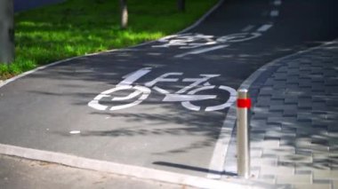 Şehir parkındaki bisiklet yolunda bisiklet süren bir kadın. Bisikletler bisiklet yolunda sürüyordu. Bisiklet. Bisiklet tabelası. Asfalt yolda bisiklet sürmek.. 