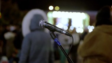 Bir sokak müzisyeninin mikrofonu seyirci kitlesi için şarkı söylüyor. Tutkulu bir performanstan sonra yalnız bir enstrüman. Para kazan, yaratıcılık şarkısı söyle..