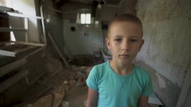 Ukrayna savaşı. Mahvolmuş bir evde Ukraynalı bir çocuğun portresi. Rusya 'nın Ukrayna' ya karşı açtığı savaştan muzdarip kirli giysiler içindeki evsiz bir çocuk. Çocuklar savaşa karşı. yıkılan şehirler, evler. kurbanlar