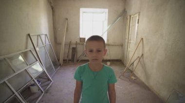 Ukrayna savaşı. Mahvolmuş bir evde Ukraynalı bir çocuğun portresi. Rusya 'nın Ukrayna' ya karşı açtığı savaştan muzdarip kirli giysiler içindeki evsiz bir çocuk. Çocuklar savaşa karşı. yıkılan şehirler, evler. kurbanlar