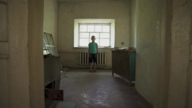 Ukrayna savaşı. Mahvolmuş bir evde Ukraynalı bir çocuğun portresi. Rusya 'nın Ukrayna' ya karşı açtığı savaştan muzdarip kirli giysiler içindeki evsiz bir çocuk. Çocuklar savaşa karşı. yıkılan şehirler, evler. kurbanlar
