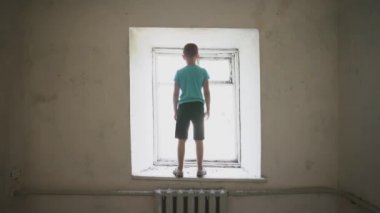 Yalnız çocuk pencereden silindi. Bekleyen yetim depresyonu yalnızlık hüzün dram yüzü. Terk edilmiş ev özlem dolu duygusal stres negatif..