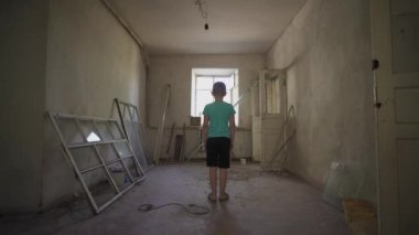 Ukrayna savaşı. Mahvolmuş bir evde Ukraynalı bir çocuğun portresi. Rusya 'nın Ukrayna' ya karşı açtığı savaştan muzdarip kirli giysiler içindeki evsiz bir çocuk. Çocuklar savaşa karşı. yıkılan şehirler, evler. kurbanlar