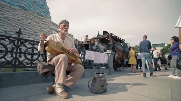 Ukrainian Musician Plays Wooden Instrument Using Burnt Russian Equipment Monuments — Stock Video
