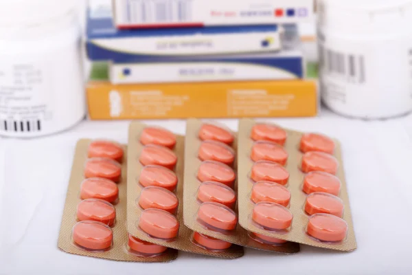 Куча таблеток рядом с пузырьками с лекарствами и коробкой от таблеток — стоковое фото