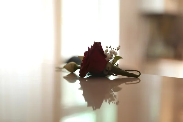 Rosa vermelha bonita em uma mesa — Fotografia de Stock