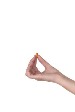 turuncu bir kapsül beyaz zemin üzerine izole tutmak el