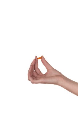 turuncu bir kapsül beyaz zemin üzerine izole tutmak el