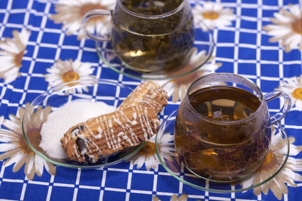 Due tazze di tè accanto a un piatto con zucchero — Foto Stock