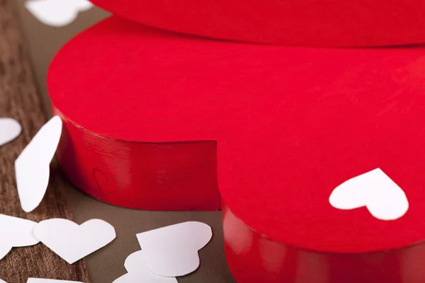 Confetti corações ao lado de uma caixa vermelha em forma de coração — Fotografia de Stock