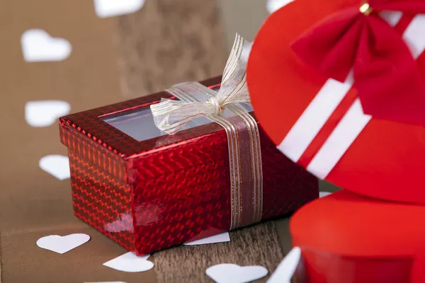 Confezione regalo accanto alla scatola rossa a forma di cuore su un backgroun artistico — Foto Stock