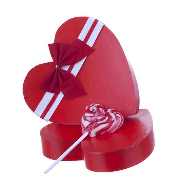 Caixa vermelha em forma de coração com um pirulito isolado no backgro branco — Fotografia de Stock