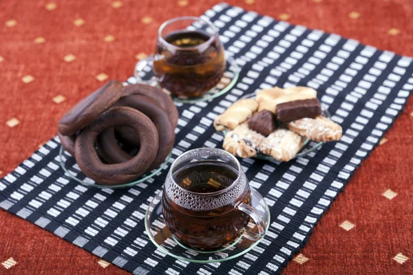 Due tazze di tè con due piatti con biscotti — Foto Stock