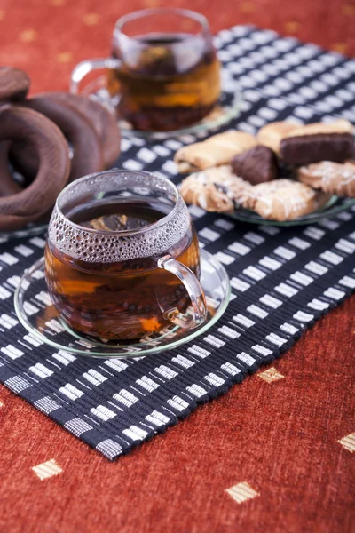 Due tazze di tè con due piatti con biscotti — Foto Stock