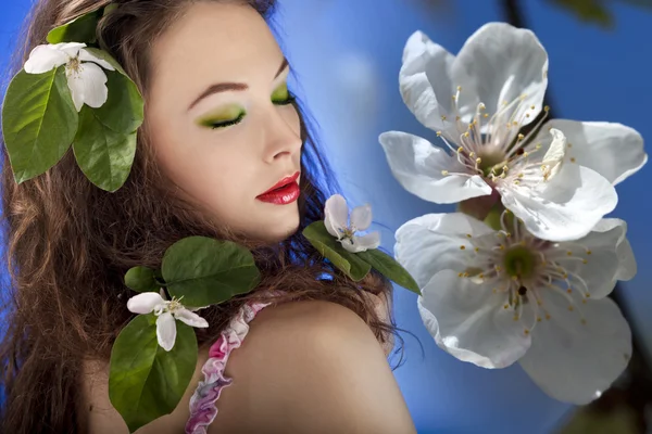 Gorgeous girl with flowers in hair. Glamour skin and make up