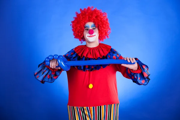 Palhaço sorridente em estúdio com balão — Fotografia de Stock