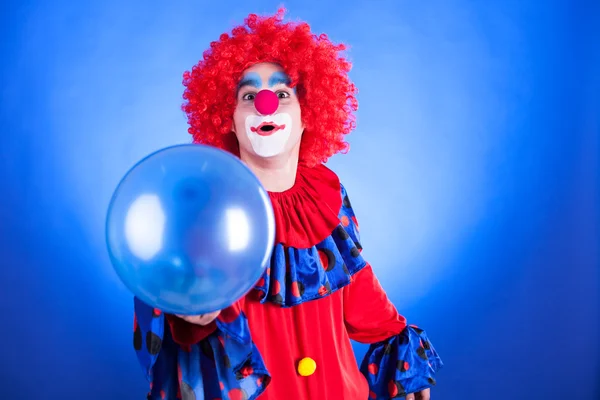 Smiling clown in studio with balloon — Stock Photo, Image