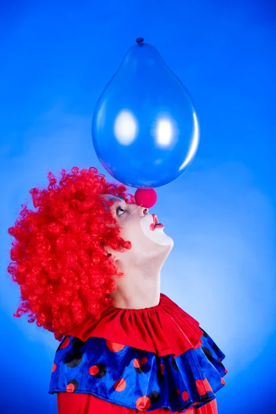 Усміхнений клоун в студії з повітряною кулею — стокове фото