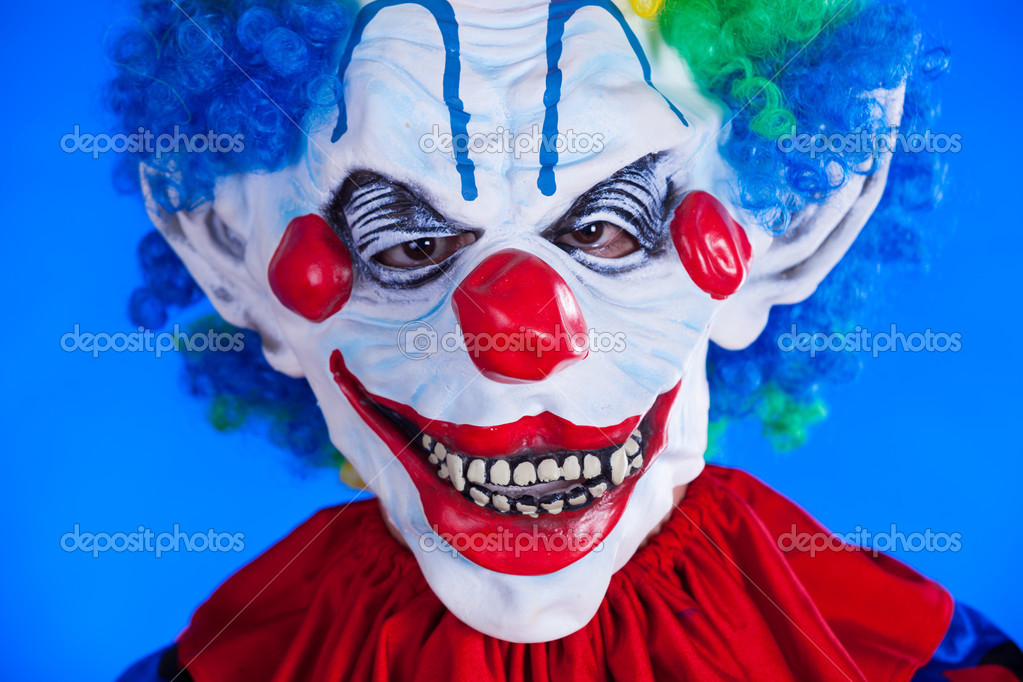 Personne clown effrayant dans le masque de clown sur fond bleu