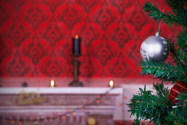 Weihnachtskugel auf rotem Vintage-Hintergrund mit brennender Kerze — Stockfoto