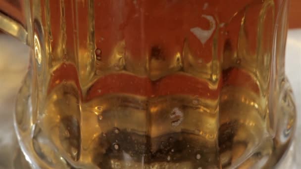 Bier in Glas auf schwarzem Hintergrund gießen — Stockvideo