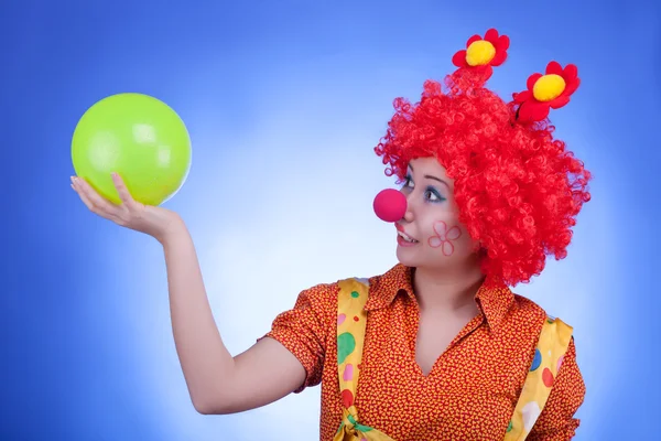 Забавная женщина-клоун на синем фоне — стоковое фото