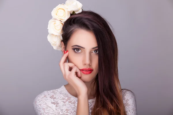 Krásná žena květiny v hlavě na šedém pozadí — Stock fotografie
