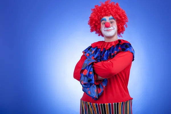Clown mannen in rood kostuum op blauwe achtergrond — Stockfoto