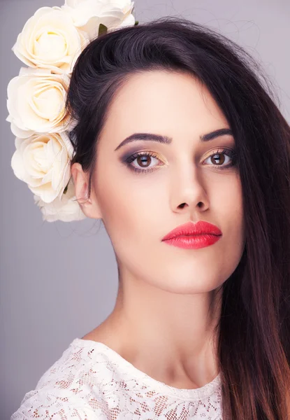 Vacker kvinna blommor i huvudet på grå bakgrund — Stockfoto