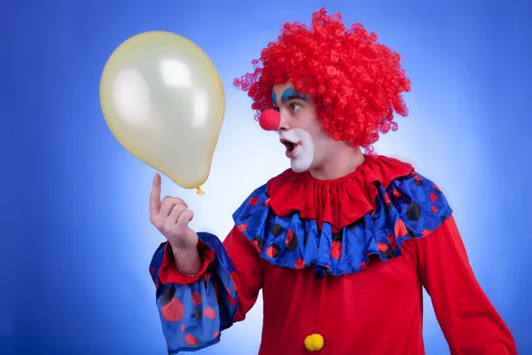 Happy clown with balloon on blue background — Stock Photo, Image