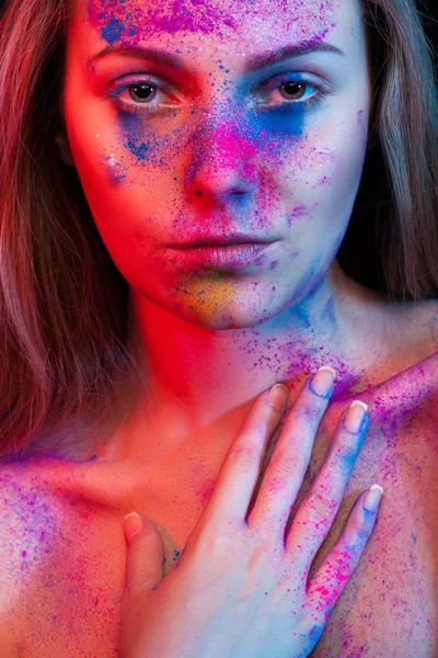 Maquillaje de moda de mujer joven y polvo de color en la cara — Foto de Stock