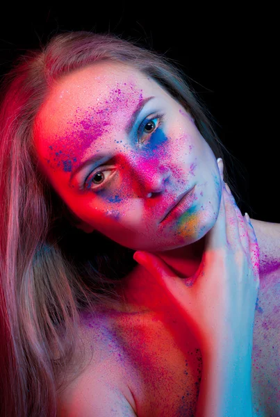 Beautiful woman with color powder on face — Stock Photo, Image