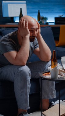 Bitkin, bunalımda, genç bir adam şakaklara masaj yapıyor.