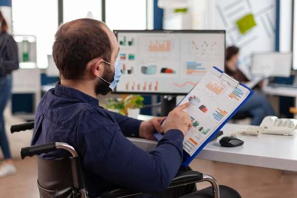 Engelli iş adamı, koronavirüs enfeksiyonunu önlemek için koruyucu yüz maskesi takıyor.