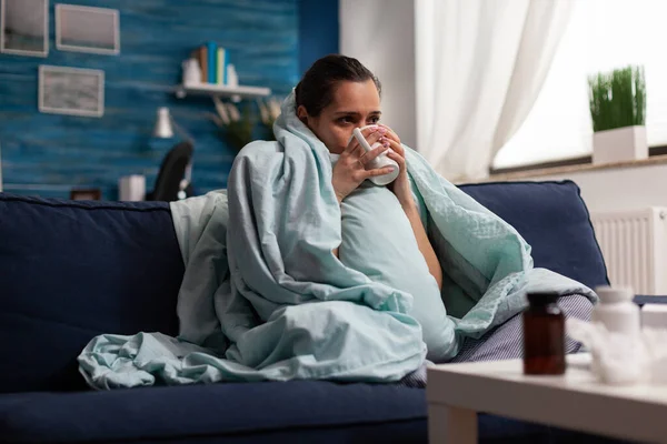 Mujer enferma en casa descansando con una taza de té —  Fotos de Stock