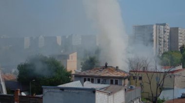Yanan evin çatısında alevleri söndürmeye çalışan itfaiyeciler.