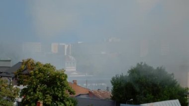 Yanan evden çıkan dumanla dolu şehir manzarası