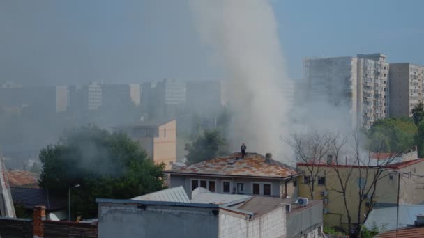 화염을 끄기 위해 불타고 있는 집의 지붕 위에 있는 소방관들 — 비디오