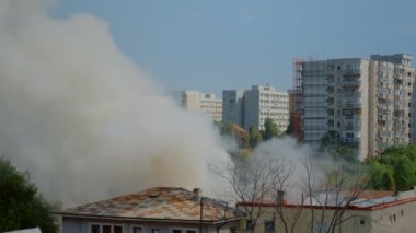 Şehrin manzarasında yanan evden çıkan alevlerin görüntüsü