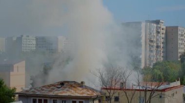 İtfaiyeciler yangını söndürmek için çatıya çıkıyorlar.
