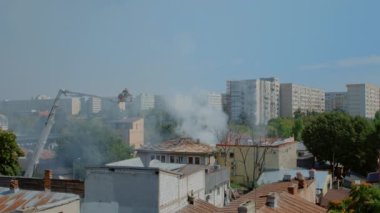 Yanan ev manzarası ve yangını söndürmeye çalışan itfaiyeciler.