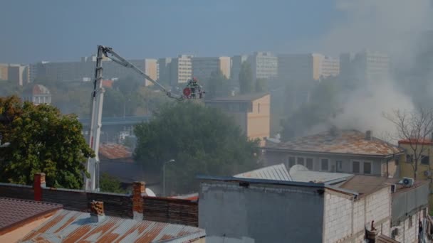 Strażacy na platformie ciężarówki czeka, aby przejść na dachu domu — Wideo stockowe