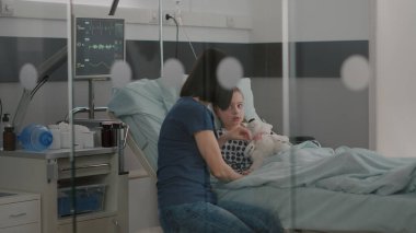 Hastane yatağında dinlenen hasta bir çocuk burun tüpü takıyor ve ameliyattan sonra iyileşiyor.
