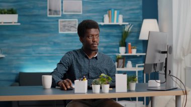 Çevrimiçi çalışma programını dinleyen, not defterine notlar alan uzaktan çalışan.