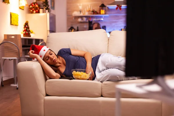Dziewczyna zasypiając na kanapie w Xmas urządzone kuchnia — Zdjęcie stockowe