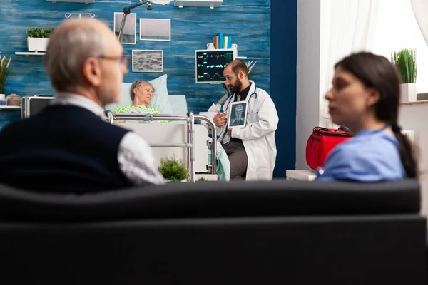 Vårdgivare man läkare arbetare förklarar röntgen diskuterar sjukdomsbehandling — Stockfoto