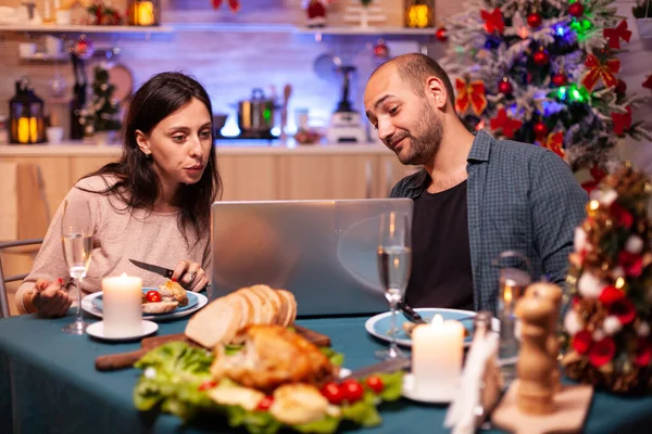 Щаслива сім'я їсть смачну різдвяну вечерю, сидячи за обіднім столом — стокове фото