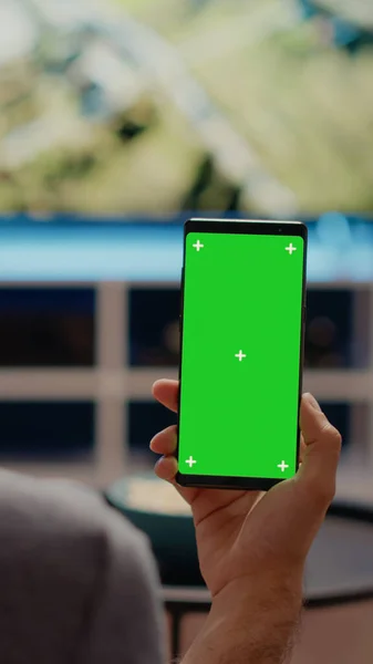 Persona in possesso di telefono cellulare con schermo verde verticalmente — Foto Stock